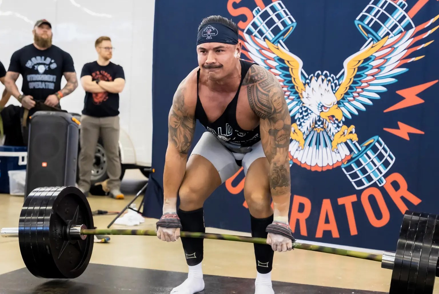 Athlete setting up for a heavy barbell deadlift at a strongman competition